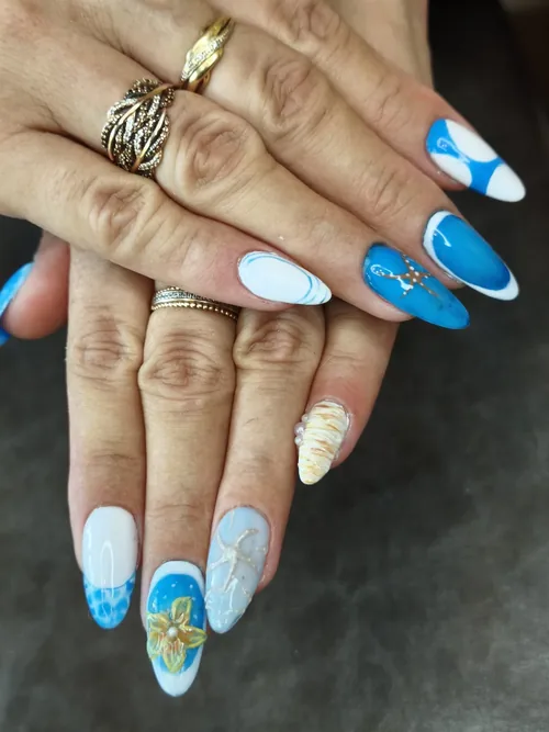 Nail art marin bleu et turquoise avec fleur dorée et motifs vagues